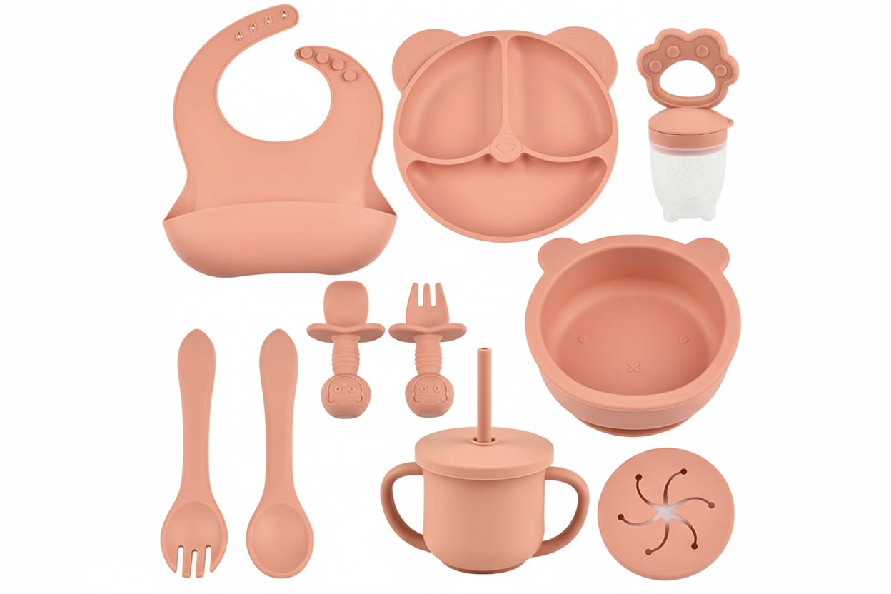 Orange baby utensil set with various items on a white background