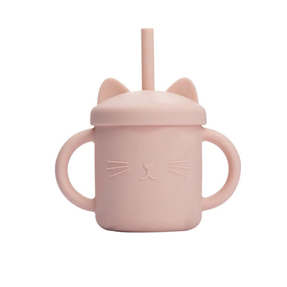 Pink sippy cup with cat ears and face design on a white background