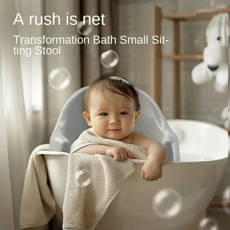 Baby in a transformation bath small sitting stool with bubbles and a teddy bear in the background.