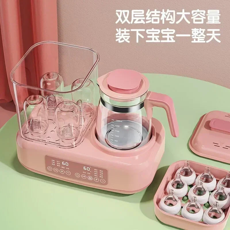 Pink baby bottle sterilizer with accessories on a green surface