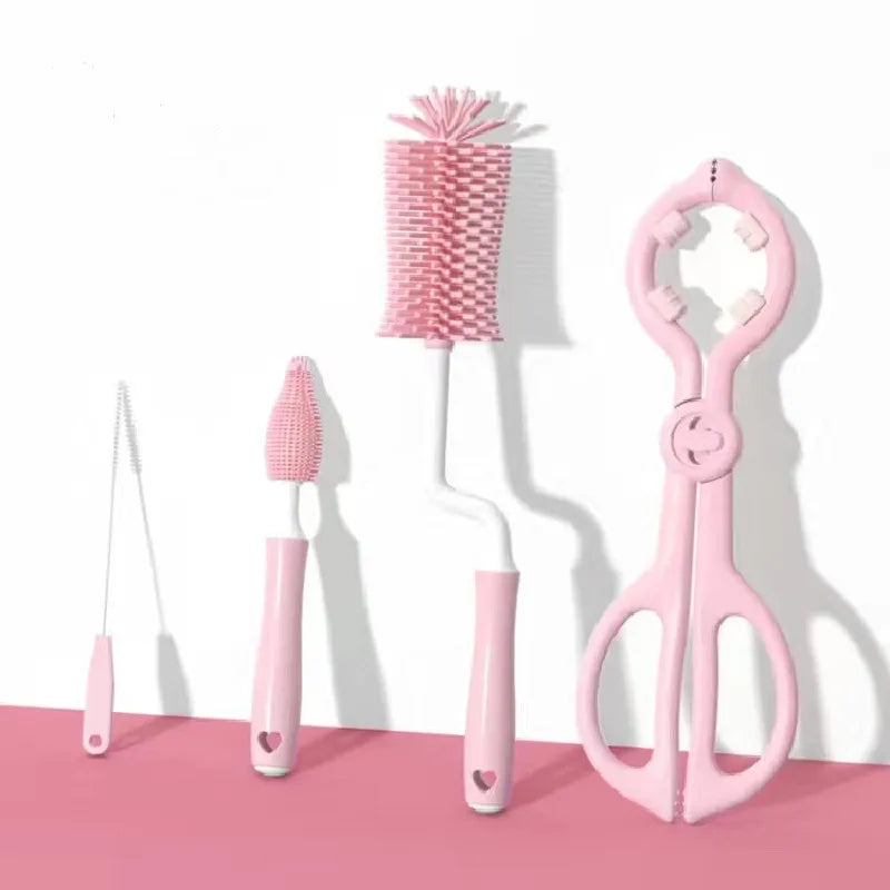 Set of pink baby cleaning tools including a bottle brush, scrubber, and scissors on a white background.