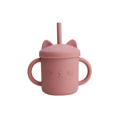 Pink sippy cup with cat ears and face design on a white background