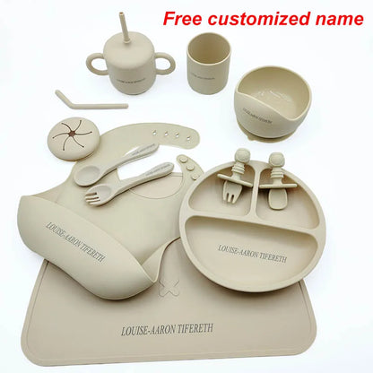 Beige children's dining set with plates, cups, and utensils on a white background.
