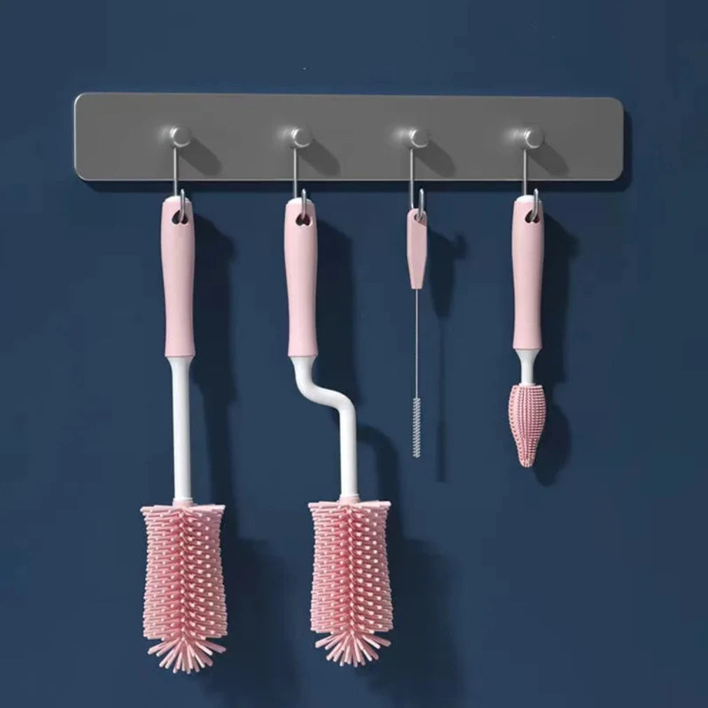 Set of four pink cleaning brushes hanging on a gray magnetic strip against a blue background
