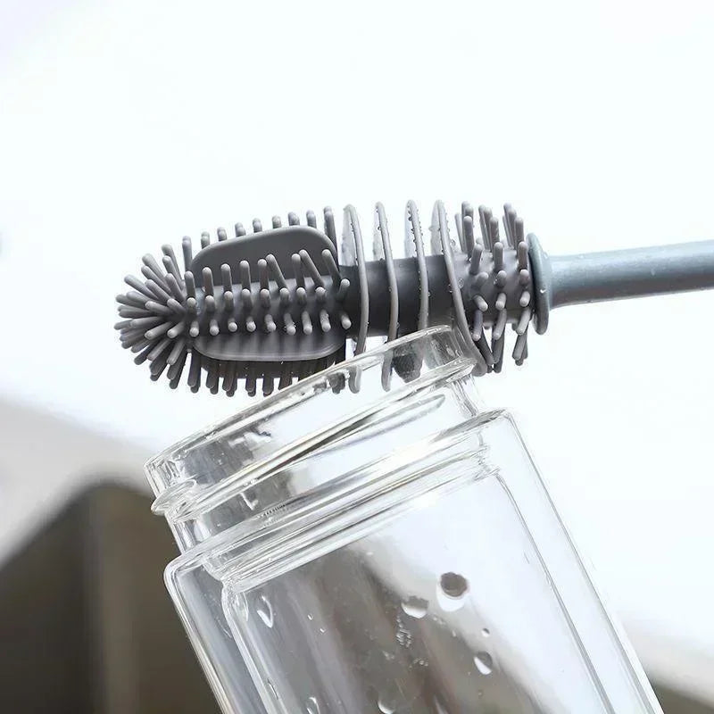 Bottle cleaning brush with bristle head and rubber handle inserted into a clear bottle.