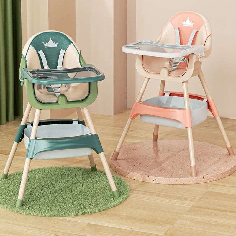 Two high chairs, one green and one pink, on a wooden floor.