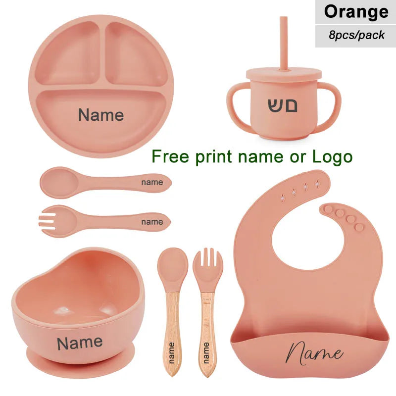 Children's dining set with pink items including a plate, cup, bowl, utensils, and bib on a white background.