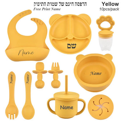 Yellow baby utensil set with various items on a white background